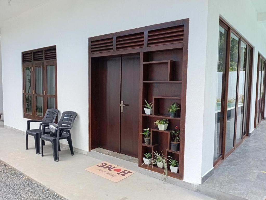 a couple of chairs sitting in front of a building at Villa Amber Breeze in Mirissa
