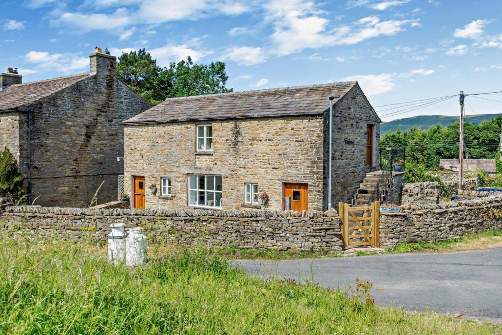 an old stone house with a stone wall at 2 Bed in Askrigg oc-b27667 in Marsett