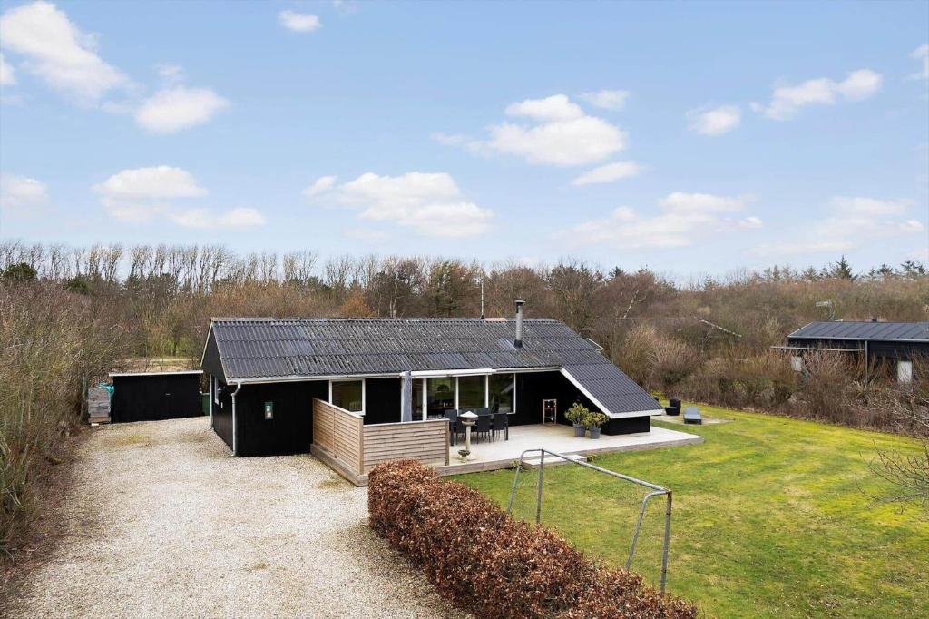 a black house with a black roof on a field at LF127-Vestervig-Gunhildsvej-27 in Vestervig