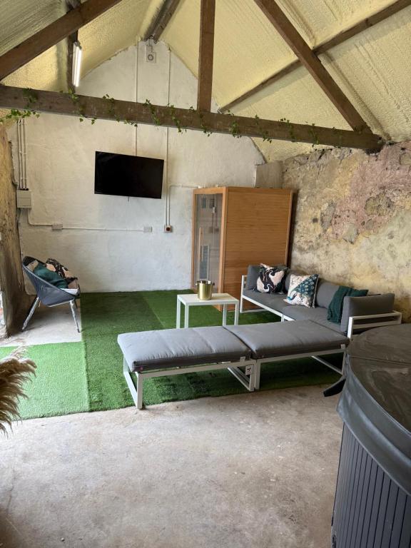 a room with a bed and a couch and a tv at Dessie's in Magherasaul