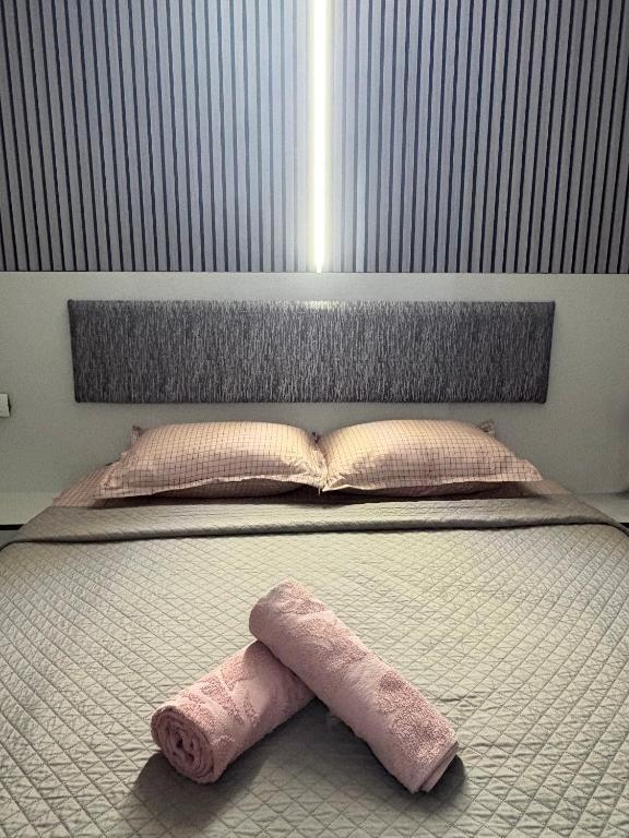a bed with a pink towel laying on it at Andya in Constanţa