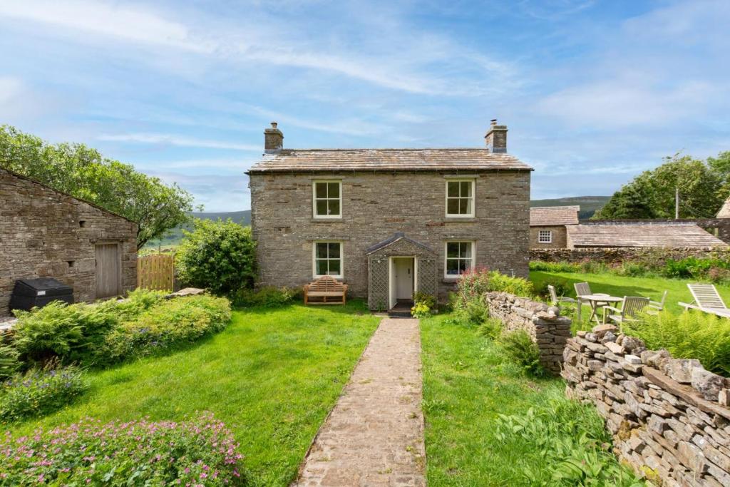 an old stone house with a garden in front of it at 3 Bed in Askrigg oc-w29833 in Marsett