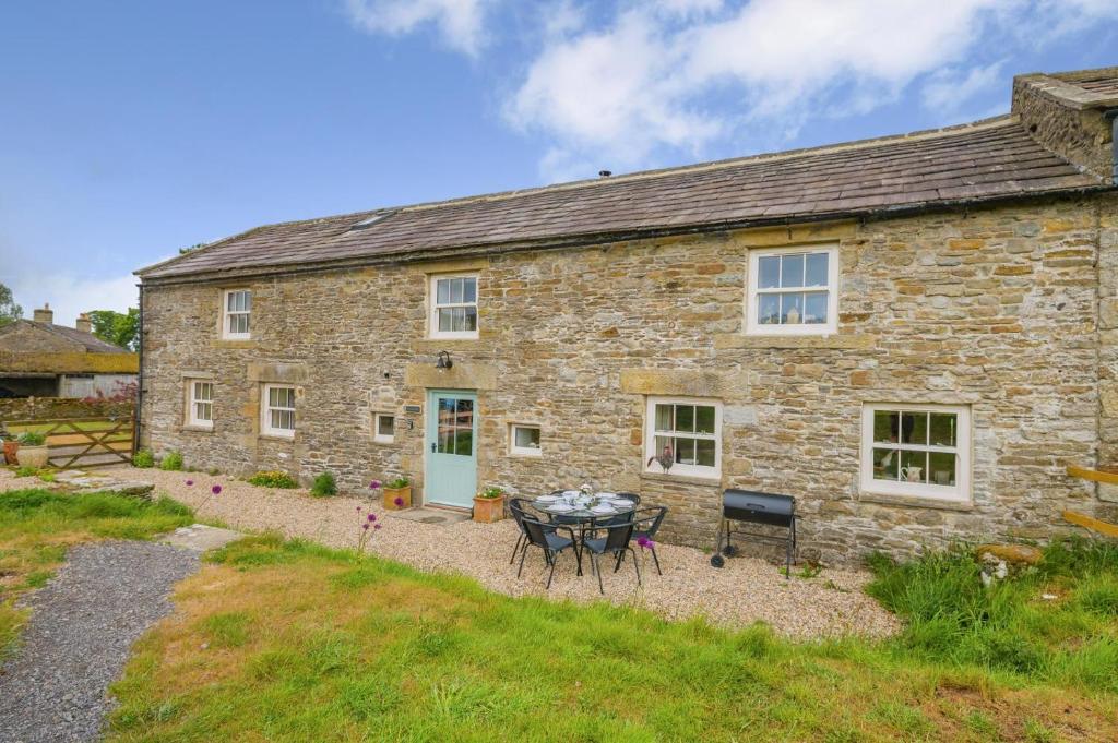 an old stone house with a table in front of it at 3 Bed in Middleham oc-o32119 in Gammersgill