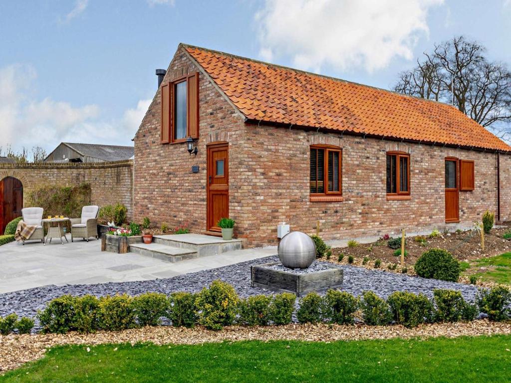 a stone house with a garden in front of it at 1 Bed in Driffield oc-79277 in Wold Newton