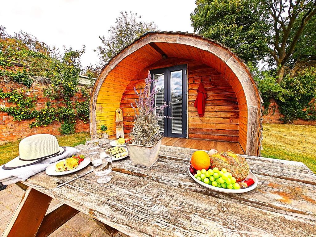 a table with fruit on it in front of a cabin at 1 Bed in Rocester oc-e33057 in Rocester
