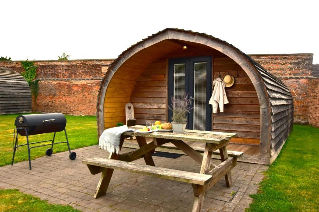 a wooden shed with a picnic table and a grill at 1 Bed in Rocester oc-w33053 in Rocester