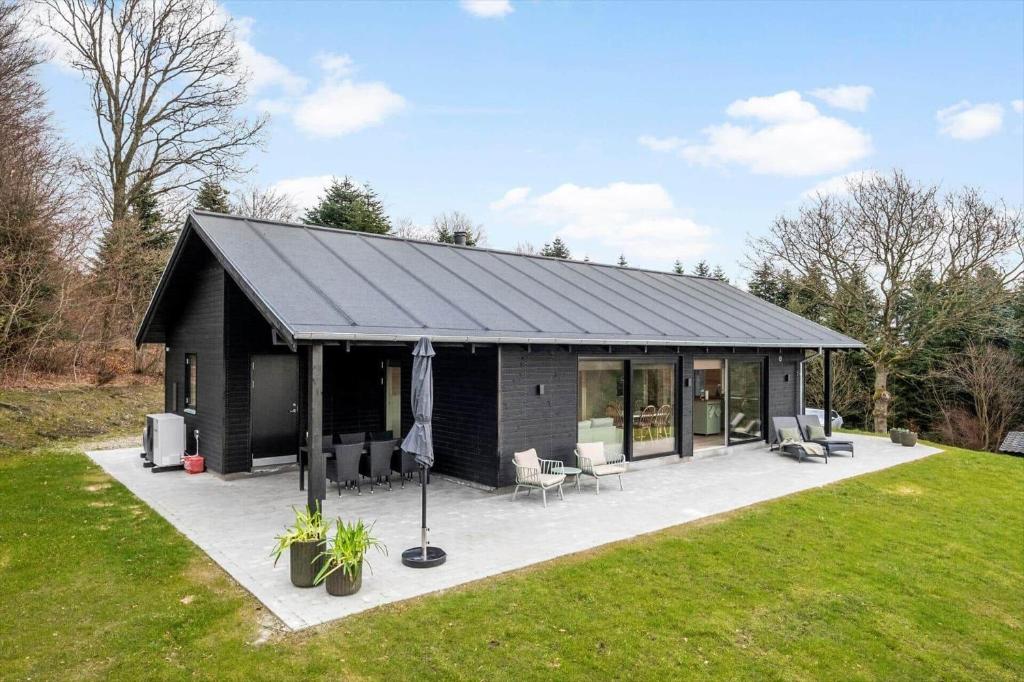 a black house with a patio in a yard at JB408-Brovst-Urbakken-2 in Brovst