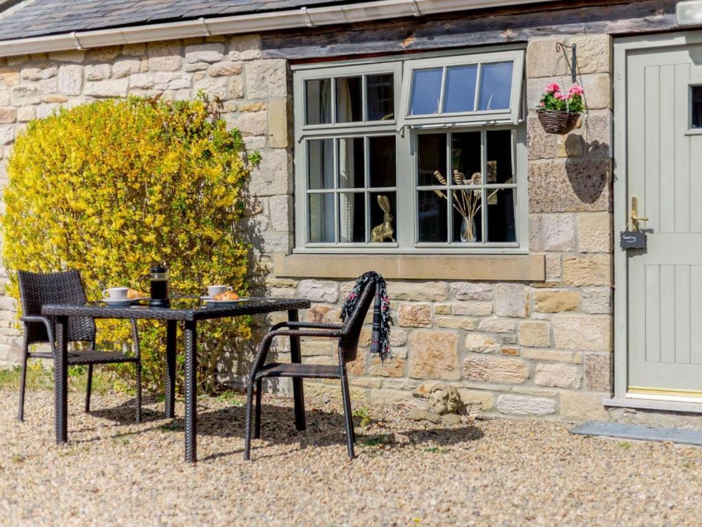 a table and two chairs in front of a building at 1 Bed in Hexham oc-82473 in Hexham
