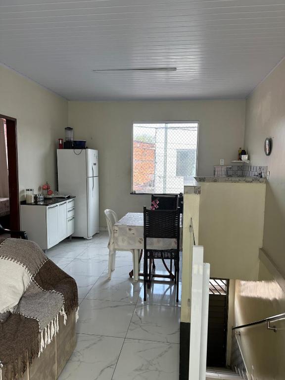 a room with a kitchen with a table and a refrigerator at Perfeita casa estilo apartamento in São Luís