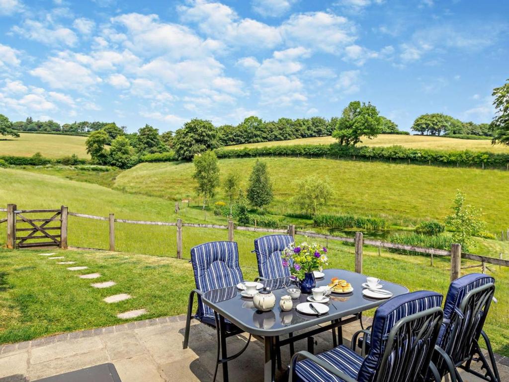 a patio with a table and chairs and a field at 2 Bed in Dulverton oc-threb in East Anstey