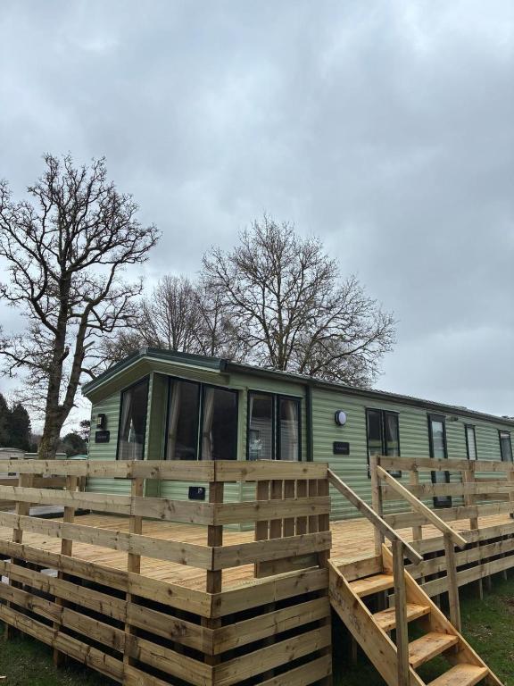 a green trailer with a wooden fence around it at The Grosvenor 45 in Ardentinny