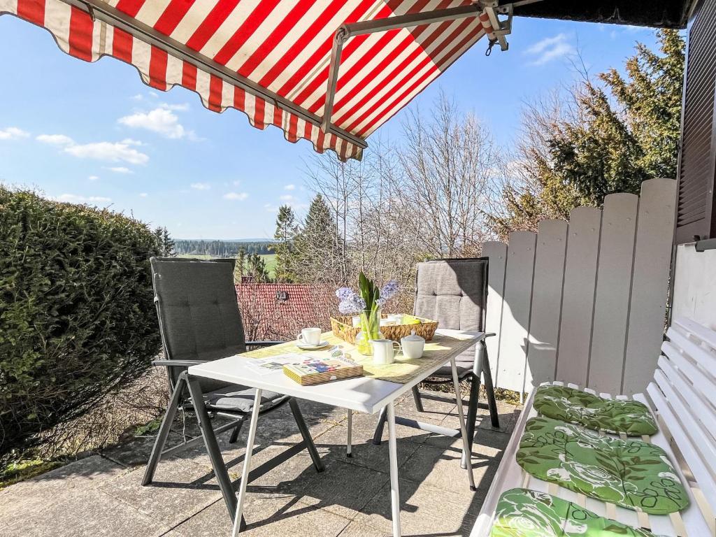 a table and chairs on a patio with an umbrella at Holiday Home Sonnenbühl by Interhome in Dittishausen