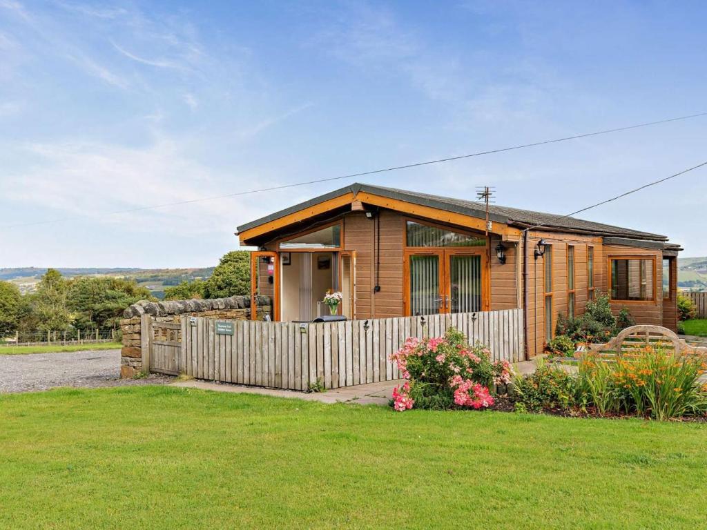 a wooden house with a fence and a yard at 2 Bed in Sowerby Bridge oc-90887 in Sowerby Bridge