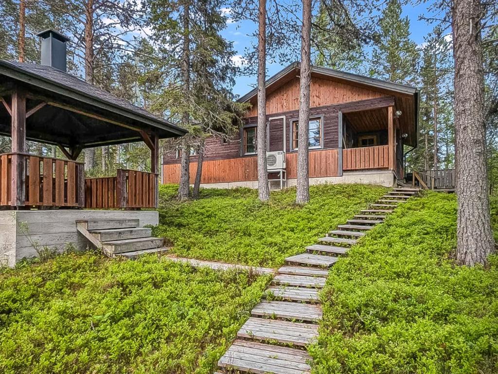a house with a porch and stairs in front of it at Holiday Home Ruskatupa by Interhome in Ruka
