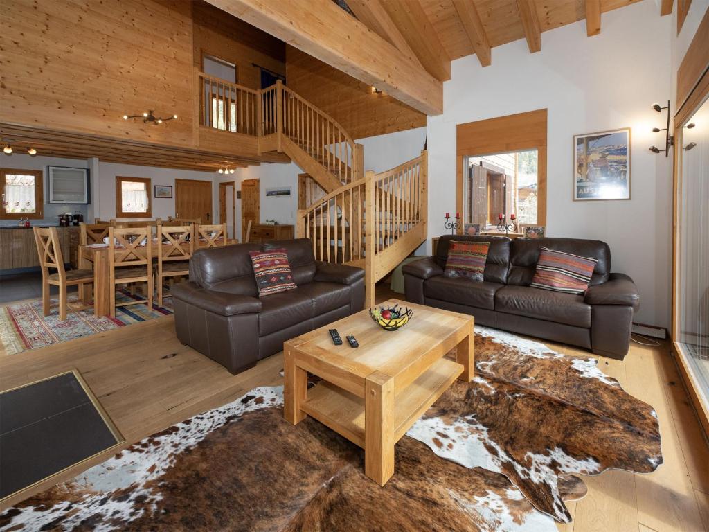 a living room with leather couches and a table at Chalet Banksia by Interhome in Ovronnaz