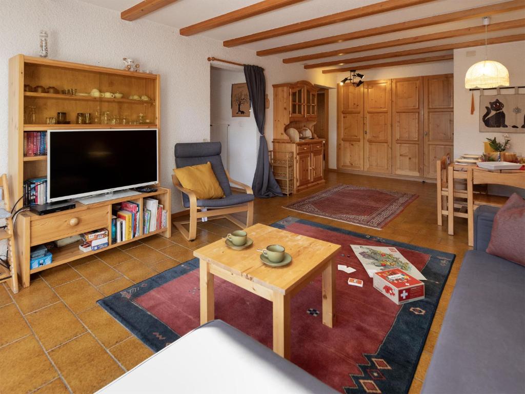 a living room with a large television and a table at Apartment Centaure B RI 1 by Interhome in Ovronnaz