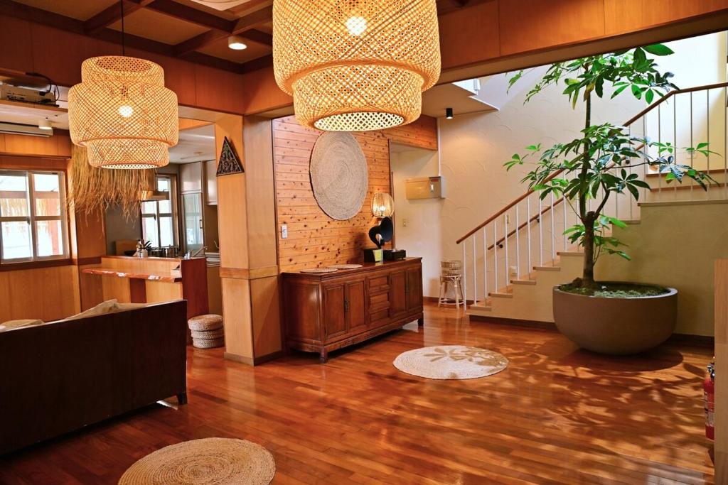 a living room with a potted tree and a staircase at 南国リゾート Bari Okinawa 連泊宿泊限定価格 in Itoman