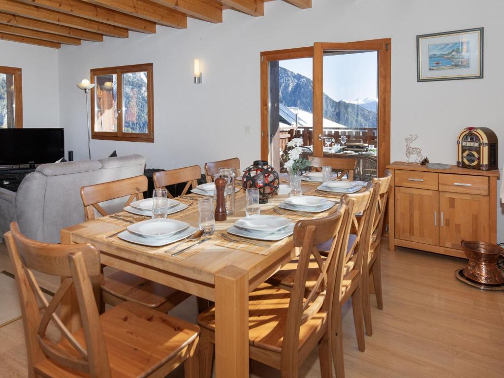 a dining room with a wooden table and chairs at Chalet Orchidée by Interhome in Ovronnaz