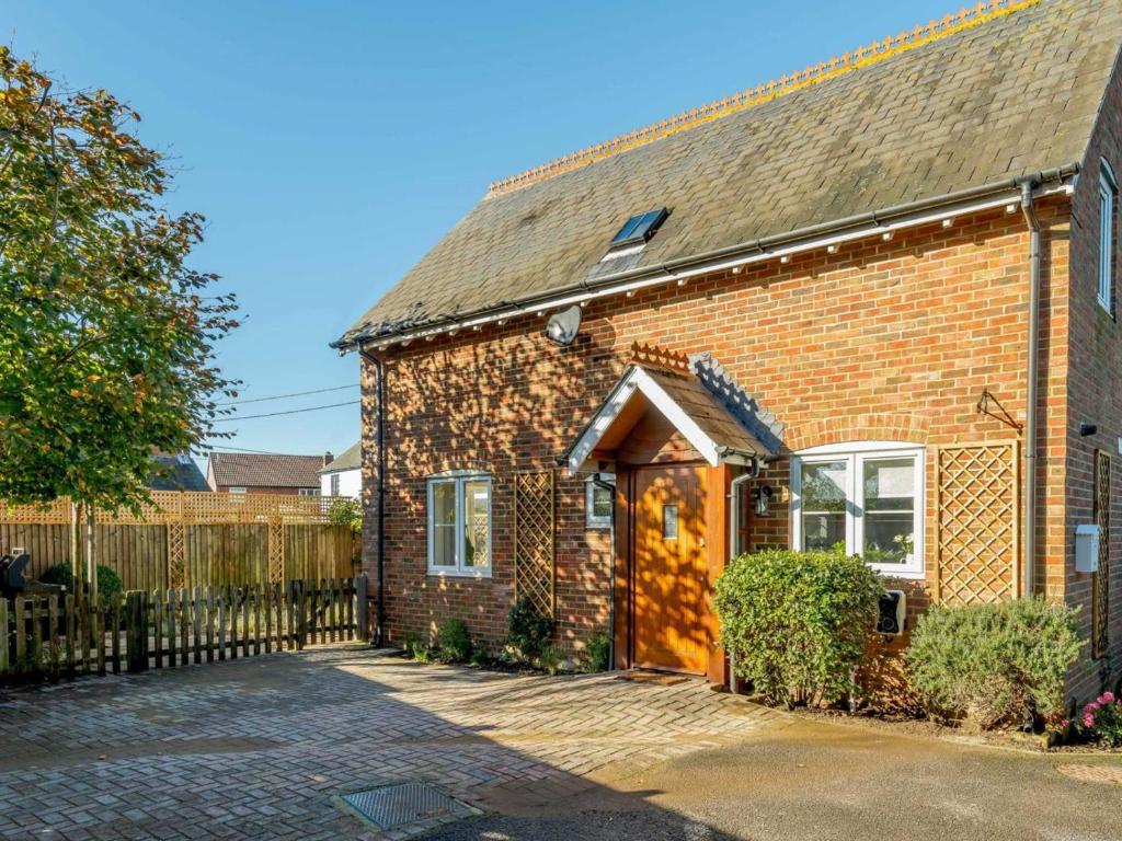 a brick house with a wooden door and a fence at 3 Bed in Lymington oc-90002 in Sway
