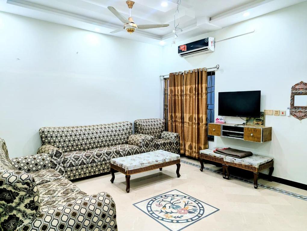 a living room with couches and a flat screen tv at House No 6, Valley Homes in Pothi