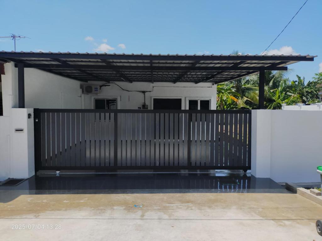 a house with a gate and a fence at Homestay Rumah 311 in Sungai Petani