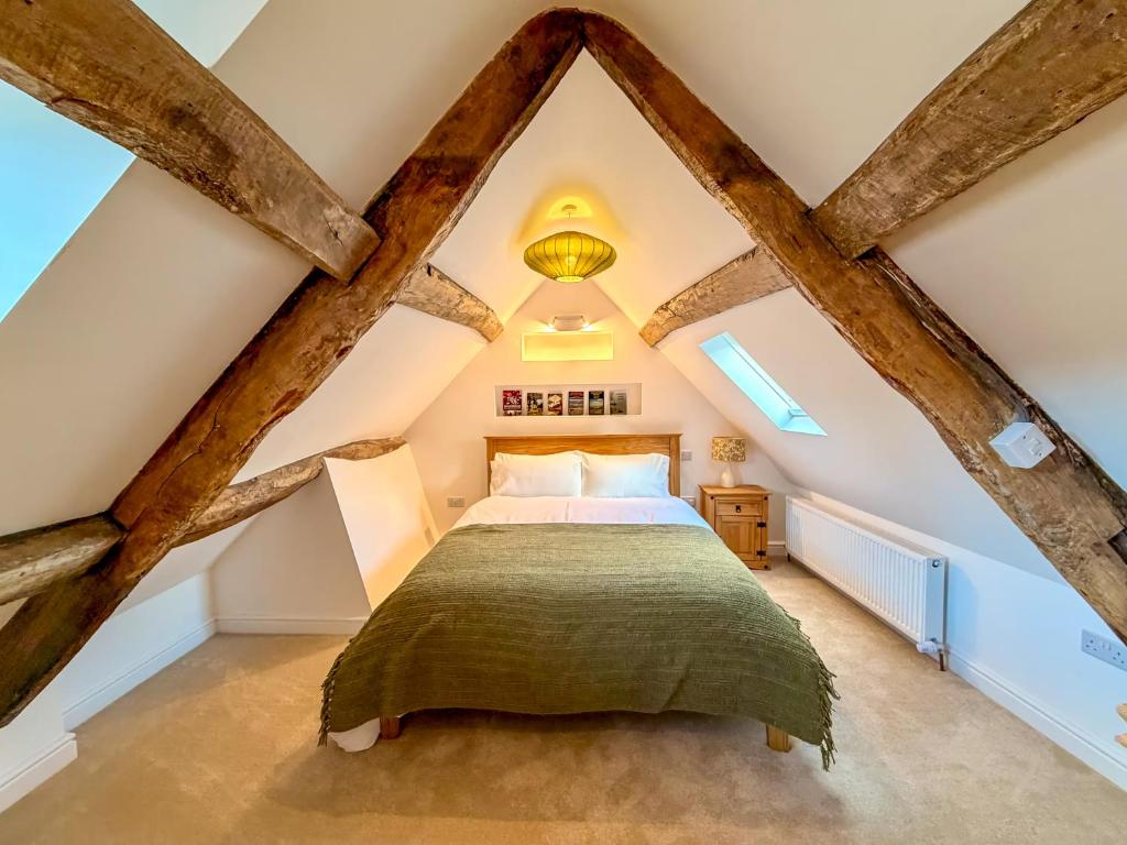 a bedroom with a bed in a attic at Broadweavers - Very Cute Cottage In Dursley By STAE-Homes in Gloucestershire