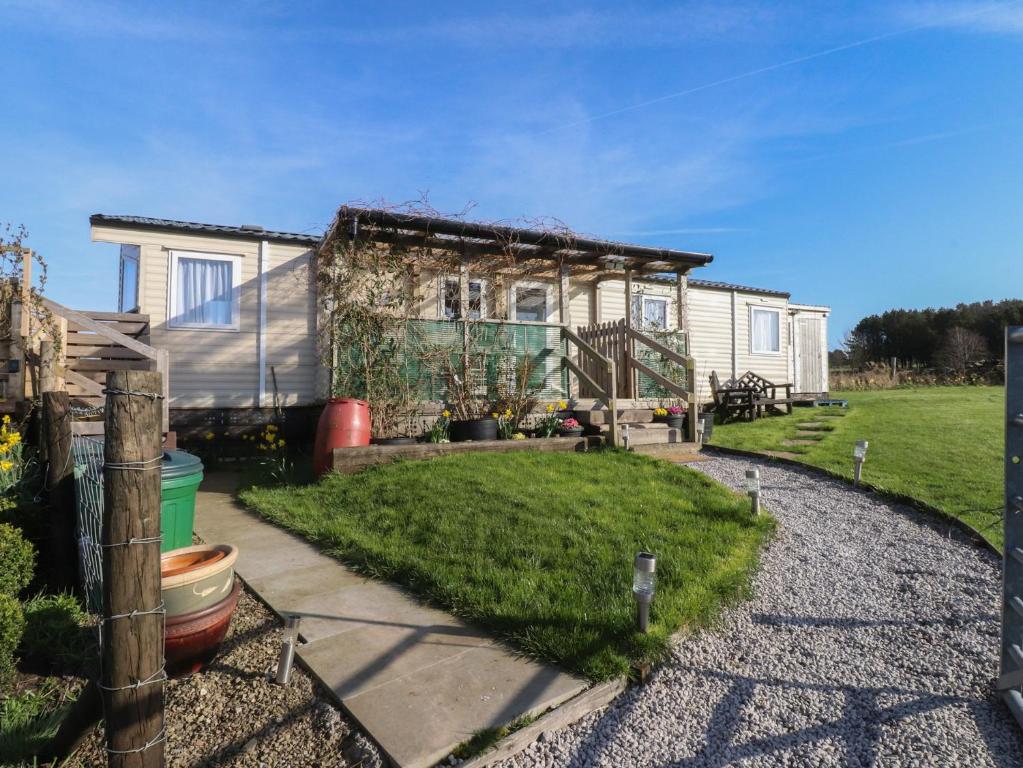 a tiny house with a gravel driveway in front of it at Cornholme Lodge in Accrington
