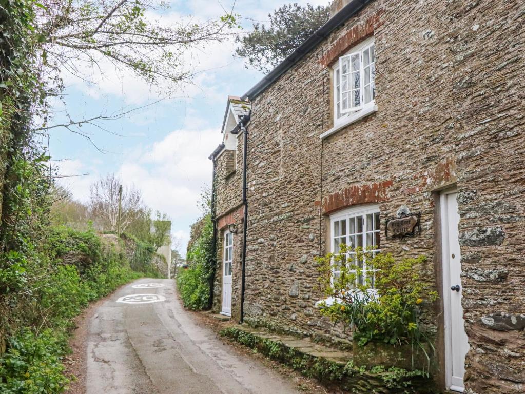 an old brick house on a dirt road at Yew Tree Cottage in Dartmouth