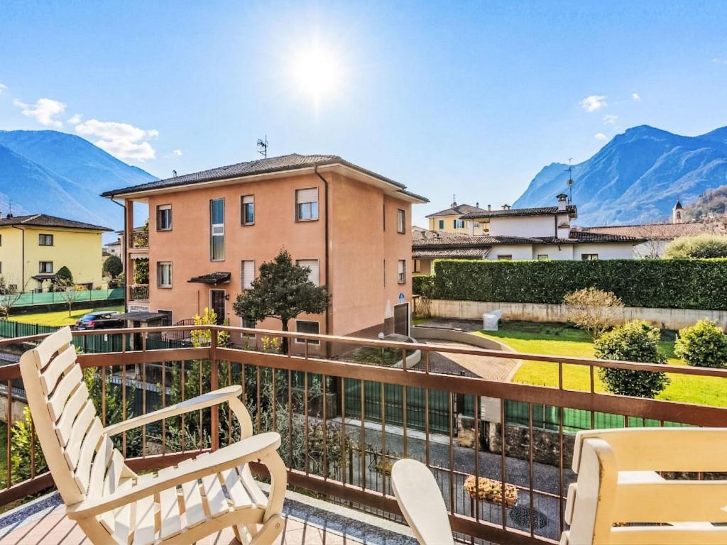 a balcony with two chairs and mountains in the background at Apartment Casa Silvia by Interhome in Carlazzo