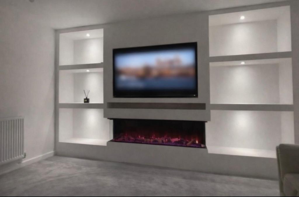 a living room with a tv and a fireplace at Blackburn House for Professionals in Blackburn