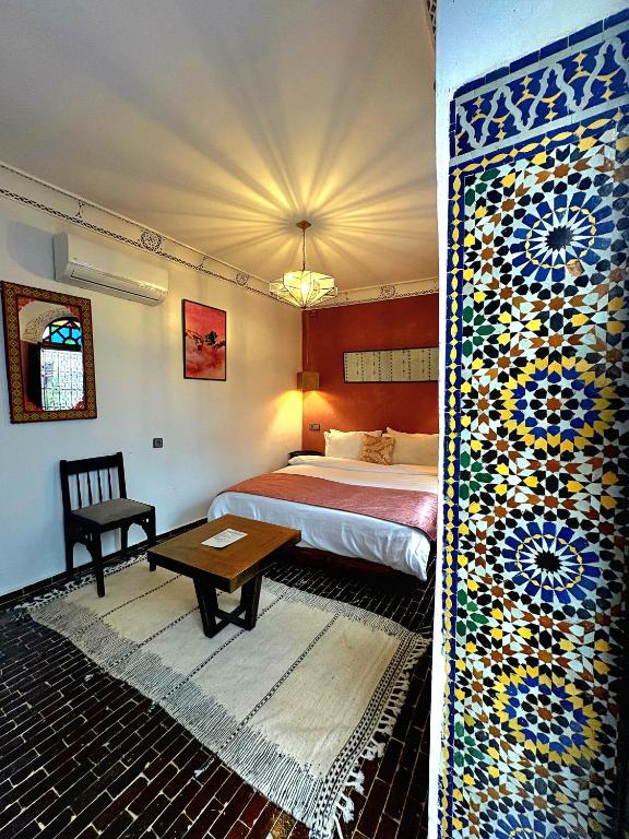 a bedroom with a bed and a table in a room at Riad Dar Mazaj Fes in Fez