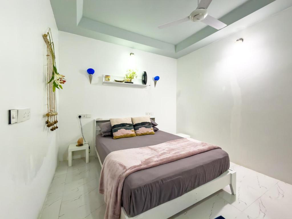 a bedroom with a bed in a white room at Diamond Stay Inn in Dhangethi