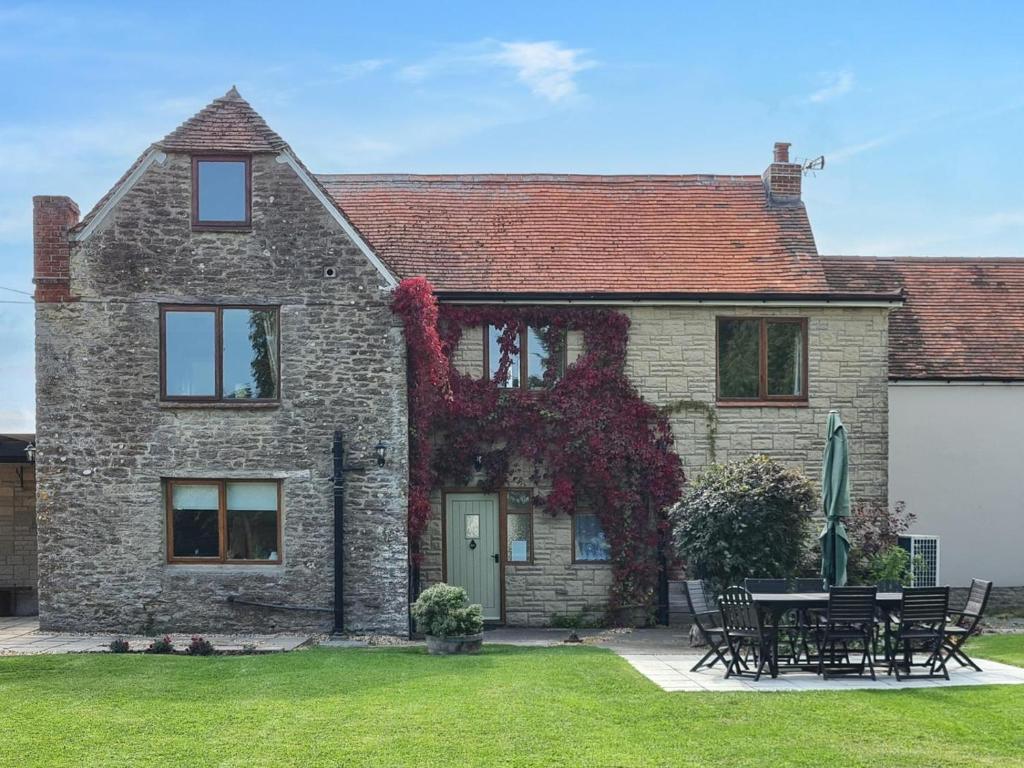 a brick house with a table and chairs in the yard at 4 Bed in Gillingham oc-80670 in West Stour