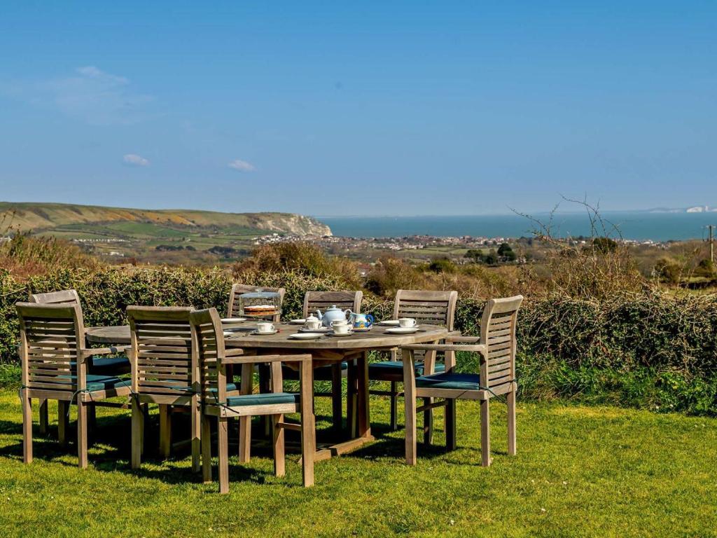 a wooden table and chairs with a table and a view at 4 Bed in Swanage oc-76659 in Langton Matravers