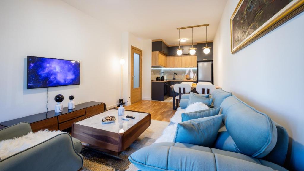 a living room with a blue couch and a table at Royal View Cetinje in Cetinje