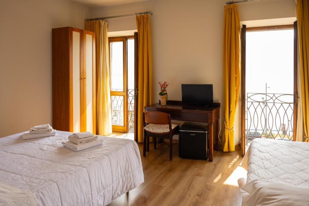 a bedroom with two beds and a desk with a computer at b&b casa pistacchio in Lovere