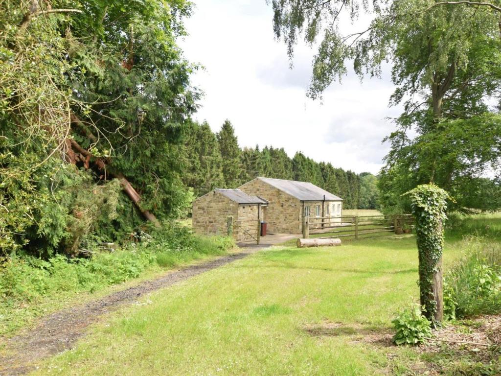 a stone building in a field next to a tree at 3 Bed in Rowlands Gill oc-cn209 in Rowlands Gill