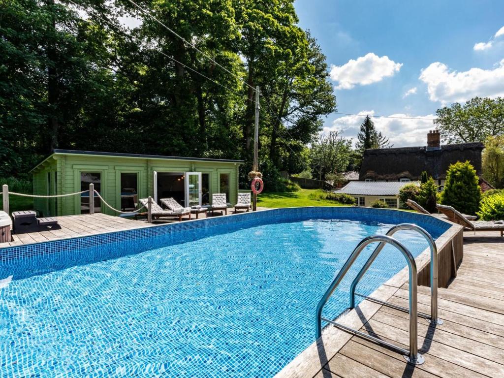 a swimming pool in a yard with a house at 6 Bed in Lymington oc-56765 in Boldre