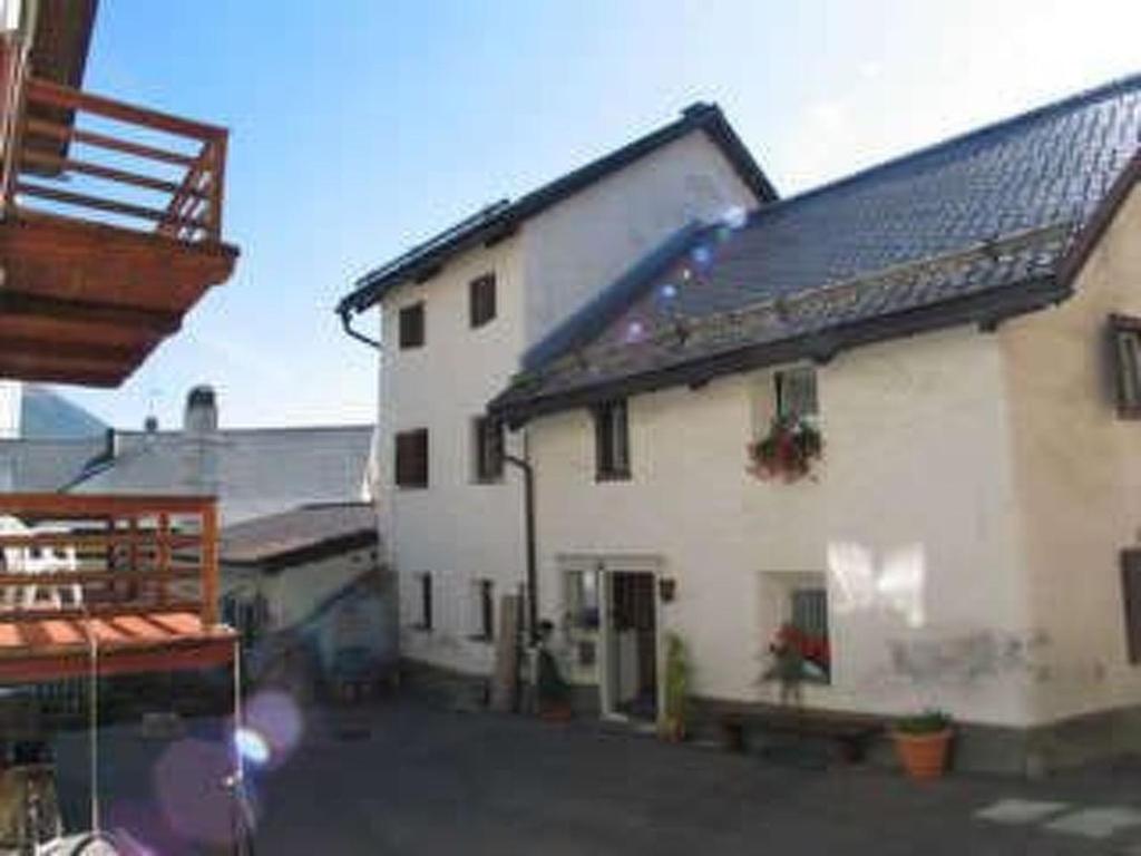 a large white building with a black roof at Apartment Chesa Treig by Interhome in Samedan
