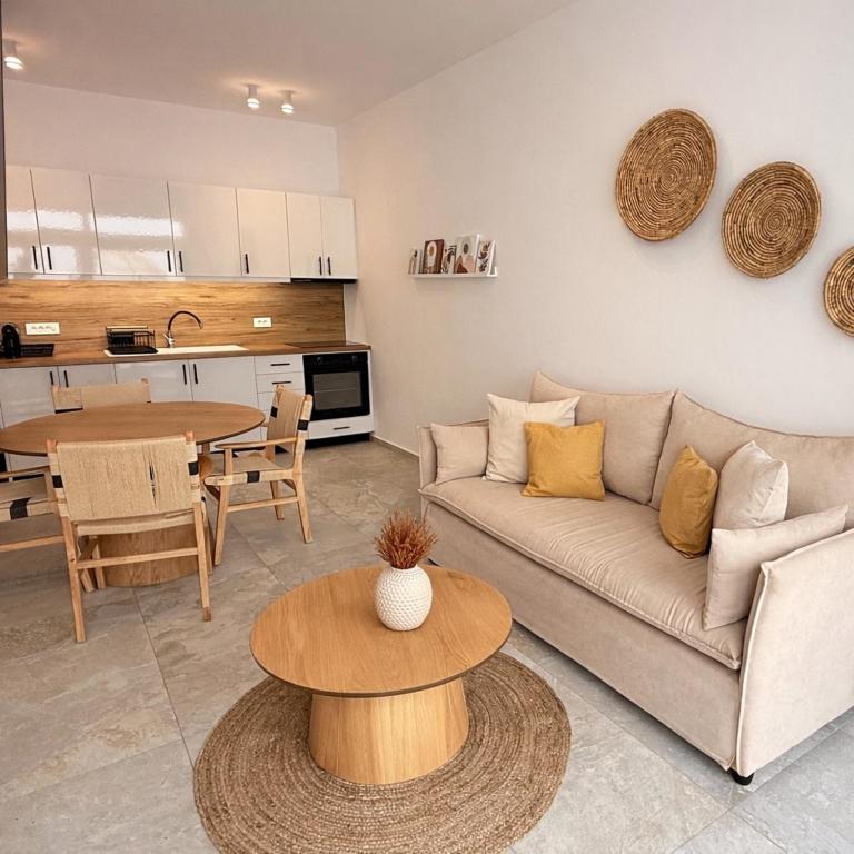 a living room with a couch and a table at MykoNest in Agios Stefanos