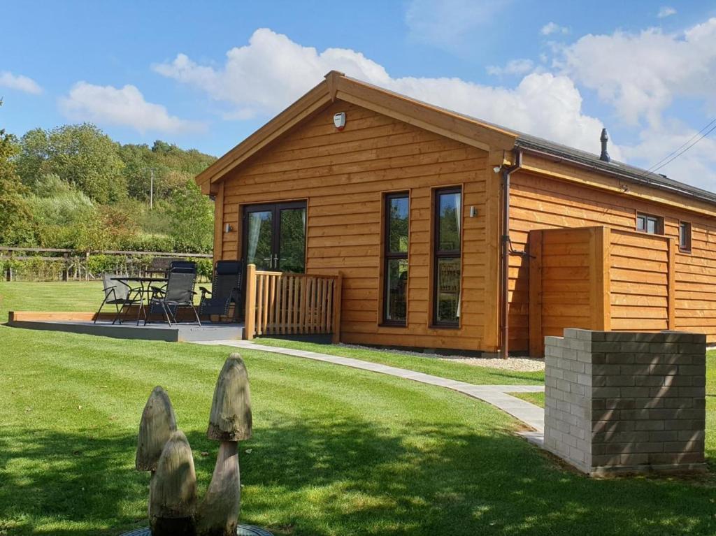a small wooden cabin with a grass yard at 3 Bed in Bridgwater oc-56284 in Greinton