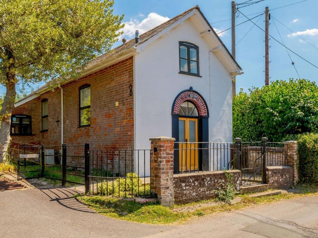 an old brick and white house with a gate at 2 Bed in Fordingbridge oc-56823 in Woodgreen