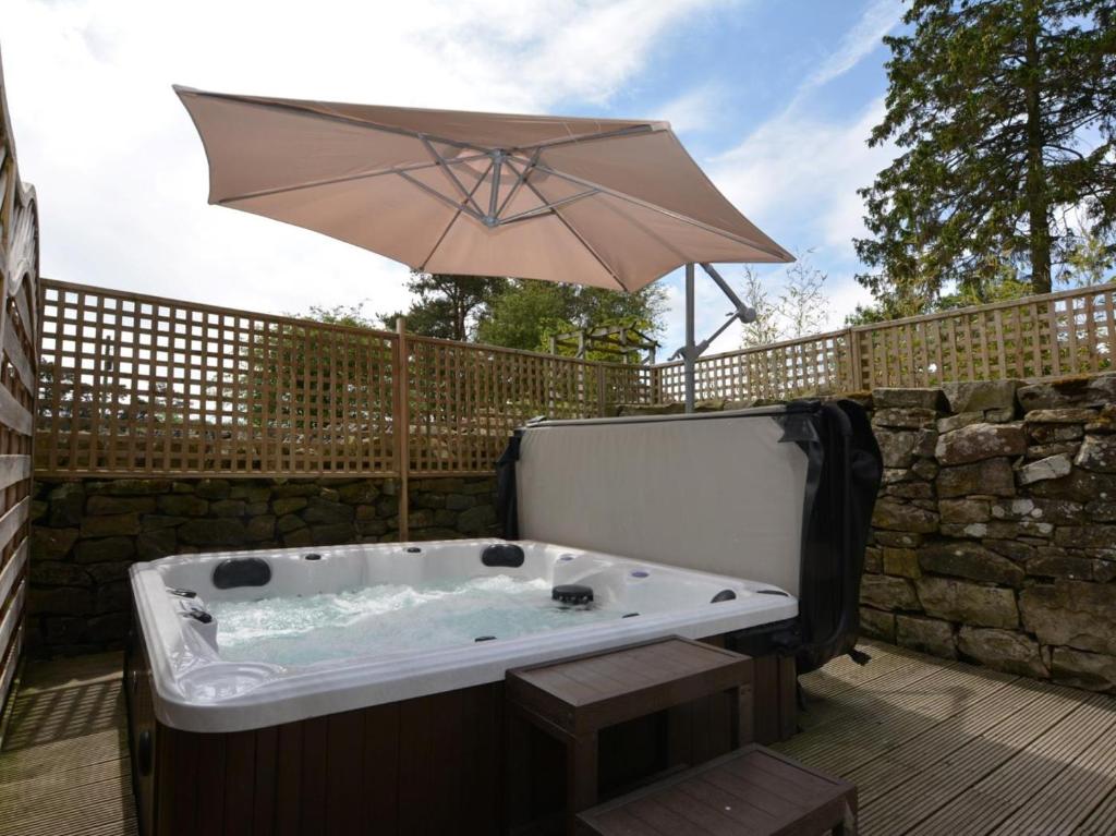 a hot tub with an umbrella on a deck at 1 Bed in Newcastle Upon Tyne oc-49414 in Rochester