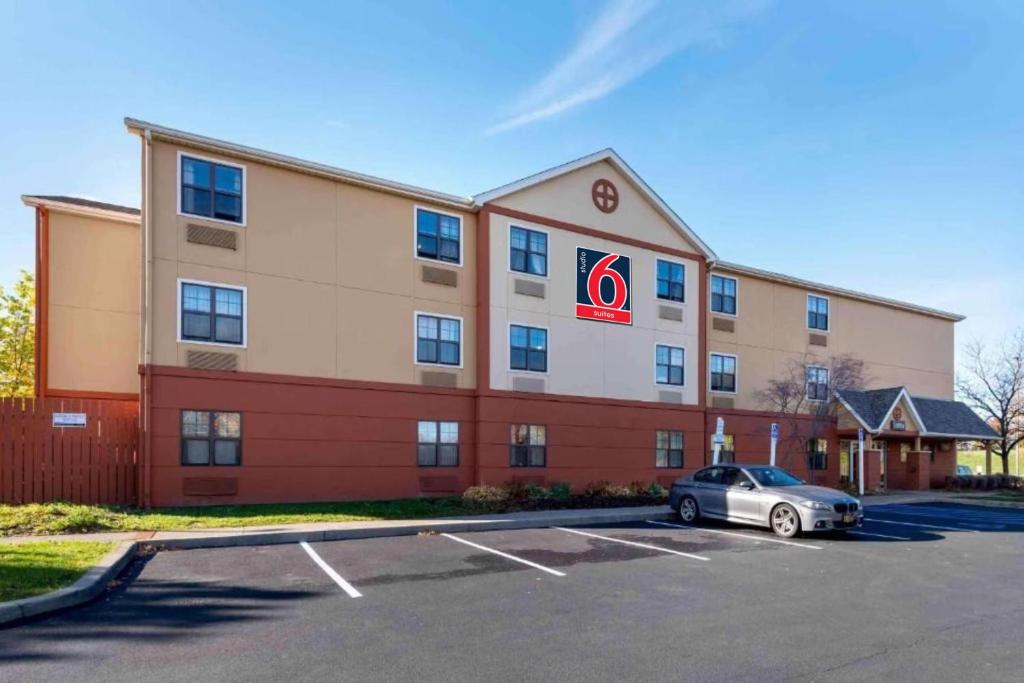 a hotel with a car parked in a parking lot at Studio 6 Corporate Extended Stay Rochester Henrietta NY in Ridgeland
