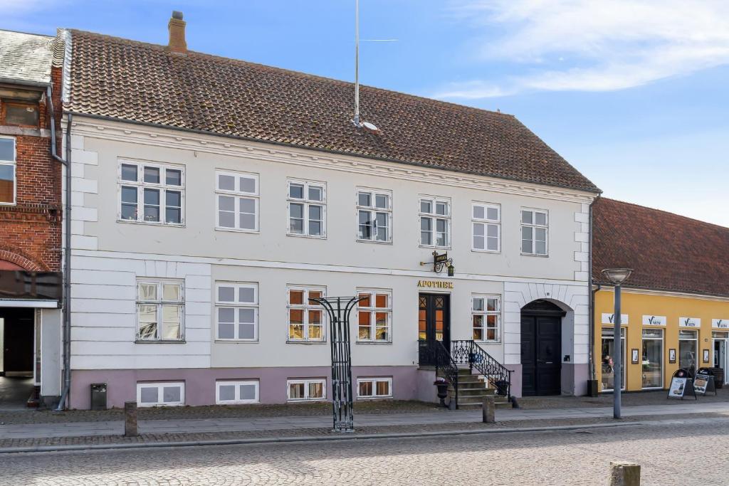 a large white building on the side of a street at Det gamle Apotek Møn in Stege