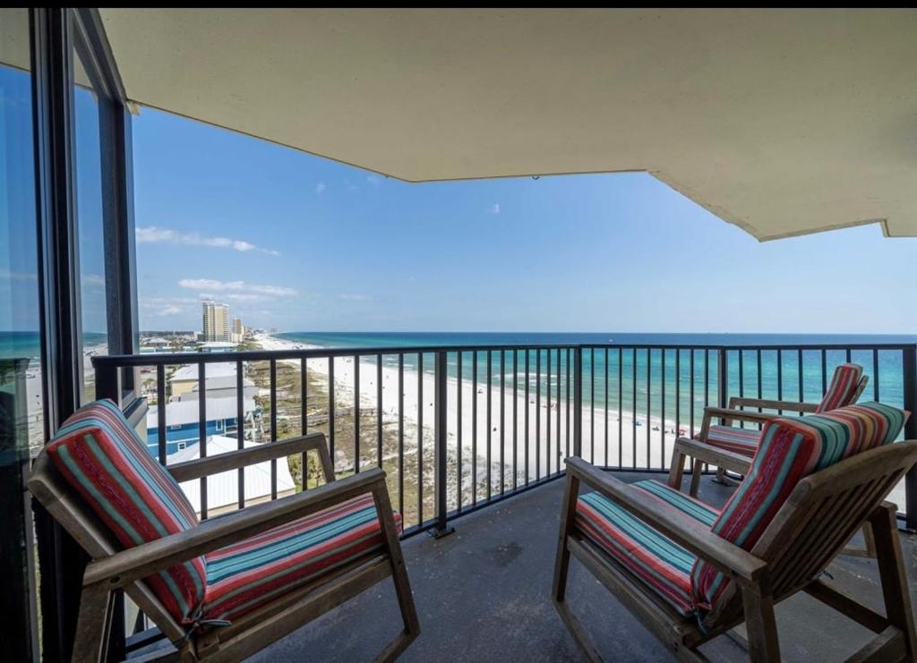 three chairs on a balcony with a view of the beach at Beachfront Condo Panama City Beach Gulf Front Views walk to Pineapple Willy's in Panama City Beach