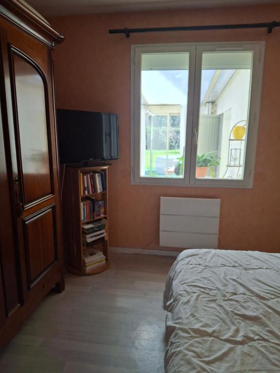 a bedroom with a bed and a window and a tv at Golf Home in Écommoy