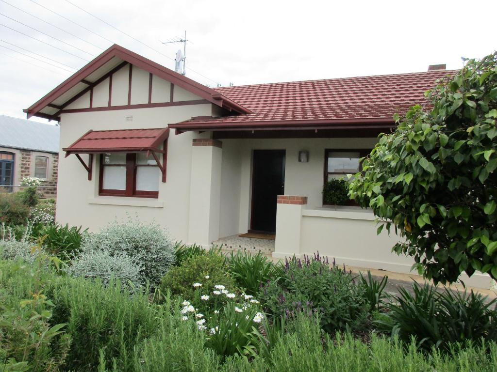 une petite maison blanche avec un toit rouge dans l'établissement Mataro Cottage, à Tanunda