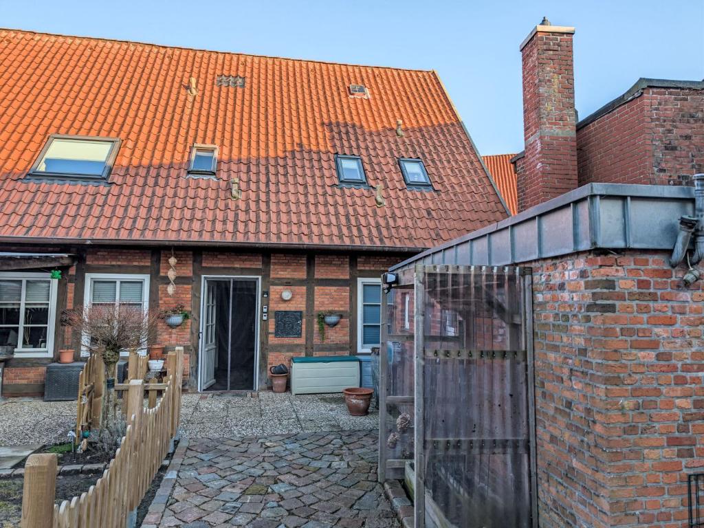 a brick house with a greenhouse in front of it at Apartment Graugans by Interhome in Freiburg - Elbe