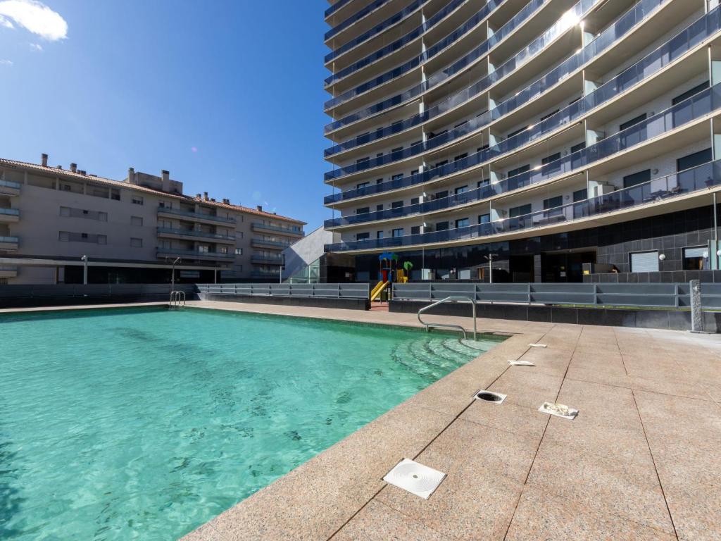 a swimming pool in front of a large building at Studio Justina by Interhome in L'Ampolla